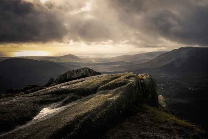 Atmospheric image of the Mourne Mountains with the light breaking through the clouds in the background
