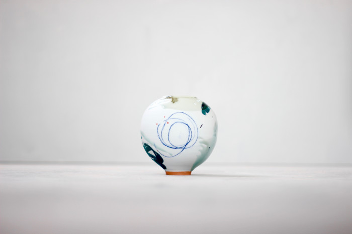 Pale blue round ceramic pot with sharp lines, crayon scribbles, brush marks and sponged back sections.